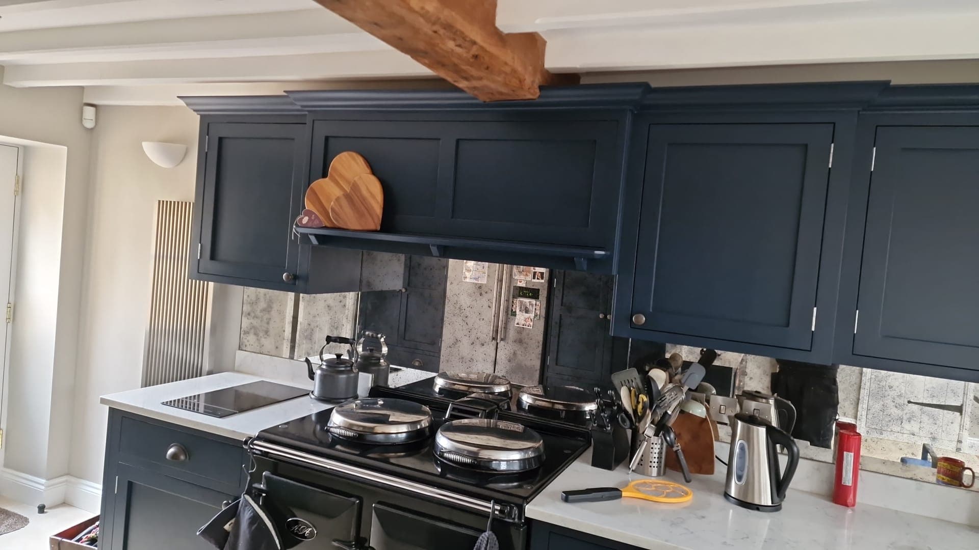 Dark kitchen cabinetry, range cooker and exposed beam